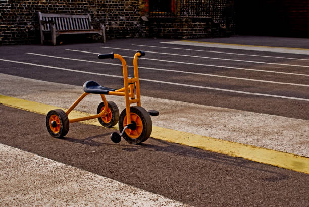 Orange tricycle on asphalt